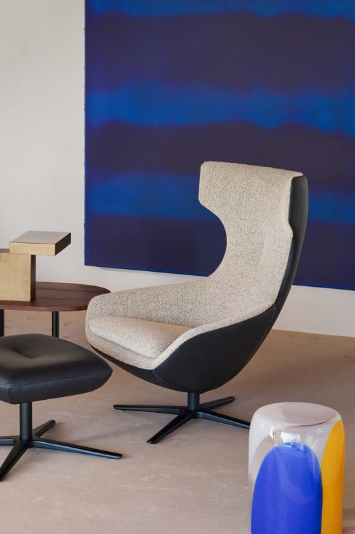 Leolux Caruzzo Lounge Chair with swivel base and rocking, reclining mechanism and footstool in premium leather and fabric combination in living room contemporary design setting