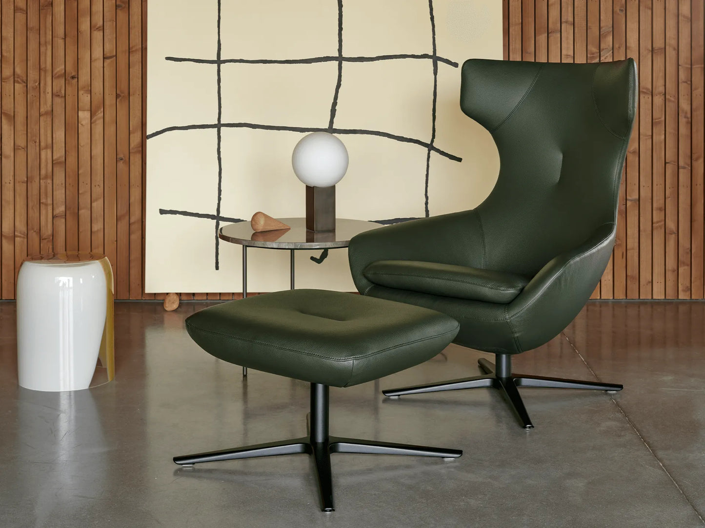 Leolux Caruzzo Lounge Chair with swivel base and rocking recliner mechanism and footstool in premium leather swivel base in living room contemporary design setting