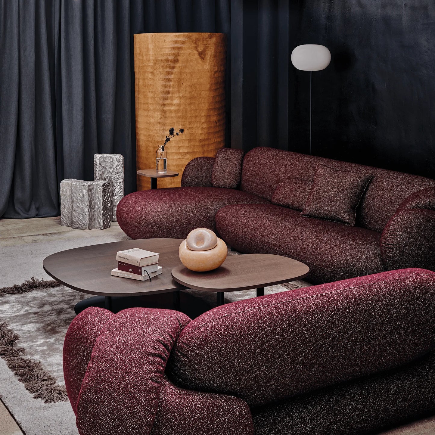 Modern living room with Leolux Pulla Sofa in burgundy red, coffee table, and decorative items.