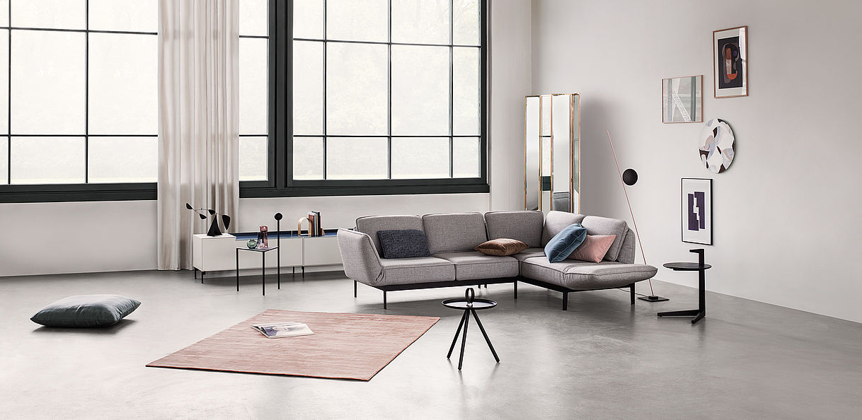 Rolf Benz Mera sectional with adjustable reclining backs in grey fabric in a modern living room 