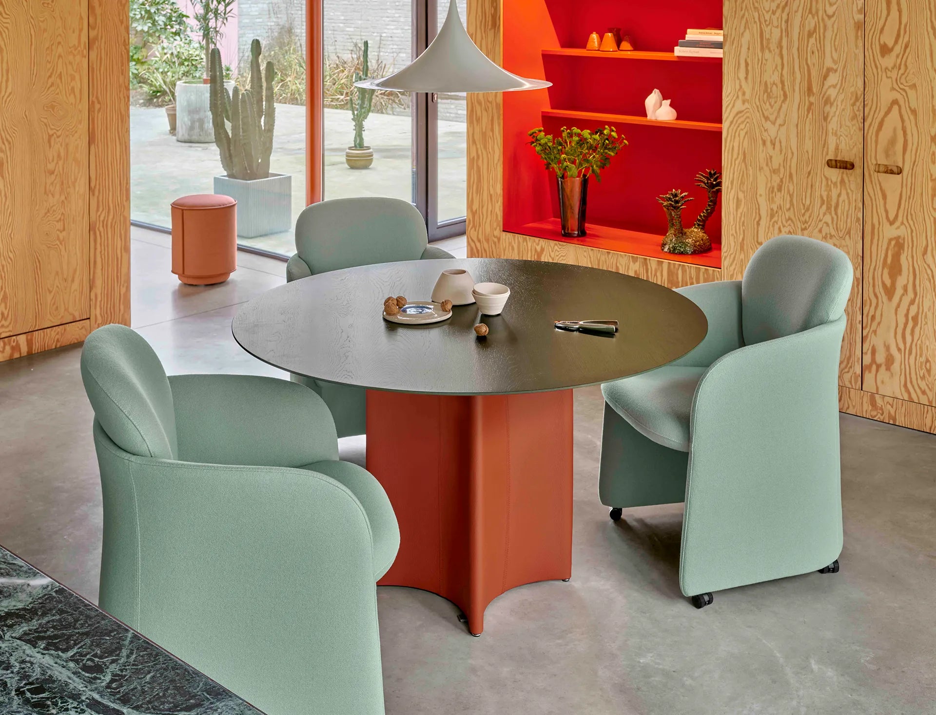 Leolux Conka Round dining table in solid oak and base in leather in modern interior with dining chairs