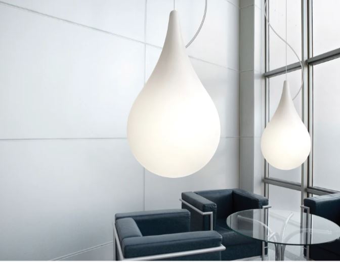 Modern interior with a hanging water drop light fixture and glass table