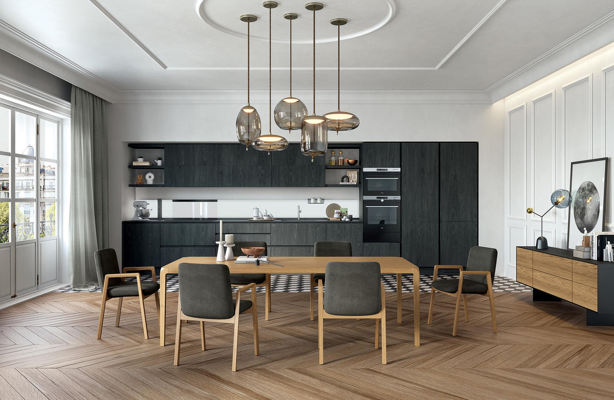 Sleek Dining Table from Riva 1920, Italy -designed by Karim Rashid. Made in Italy.  A modern dining room with a solid oak dining table and six leather upholstered chairs, set in a bright, contemporary kitchen with dark oak cabinetry and pendant lights. 