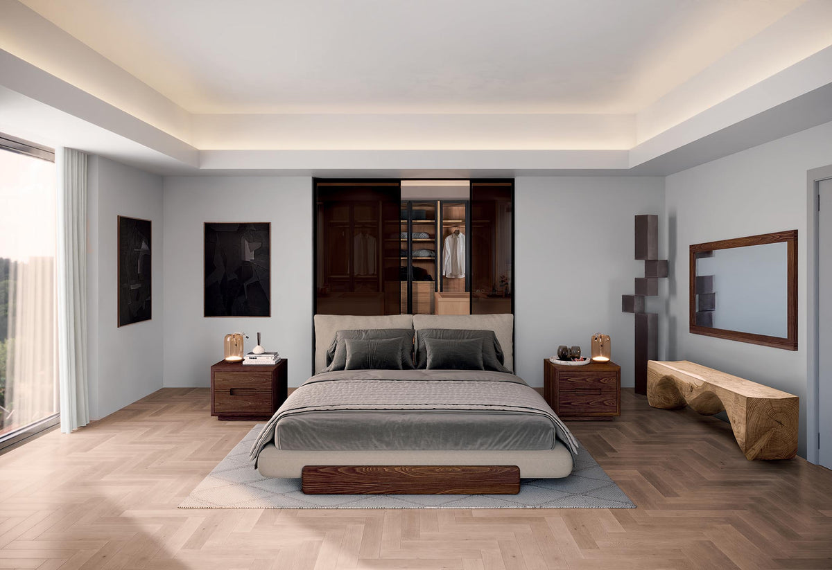 Riva 1920 Sospiro contemporary and modern wooden nightstand in solid walnut, shown with the Sospiro Bed in light fabric upholstery. The nightstand features two drawers, photographed in contemporary bedroom setting with chest of drawers and  the Sospiro Bed